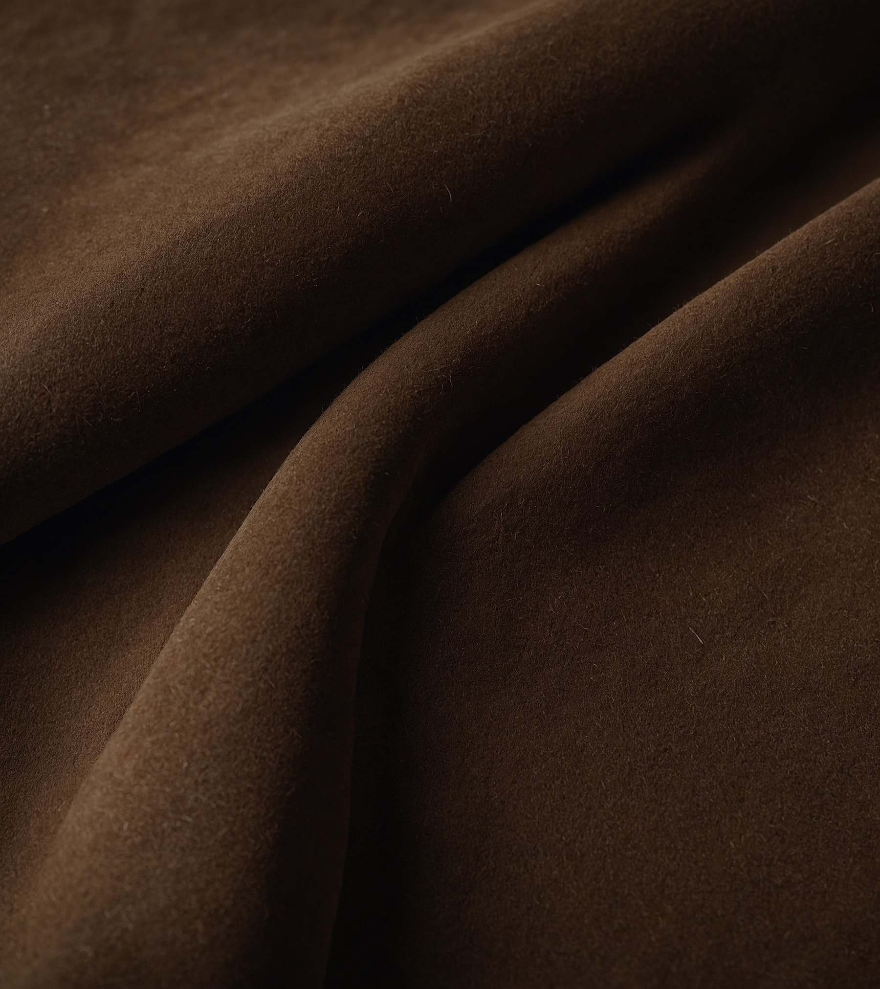 Brown textured fabric with soft folds.
