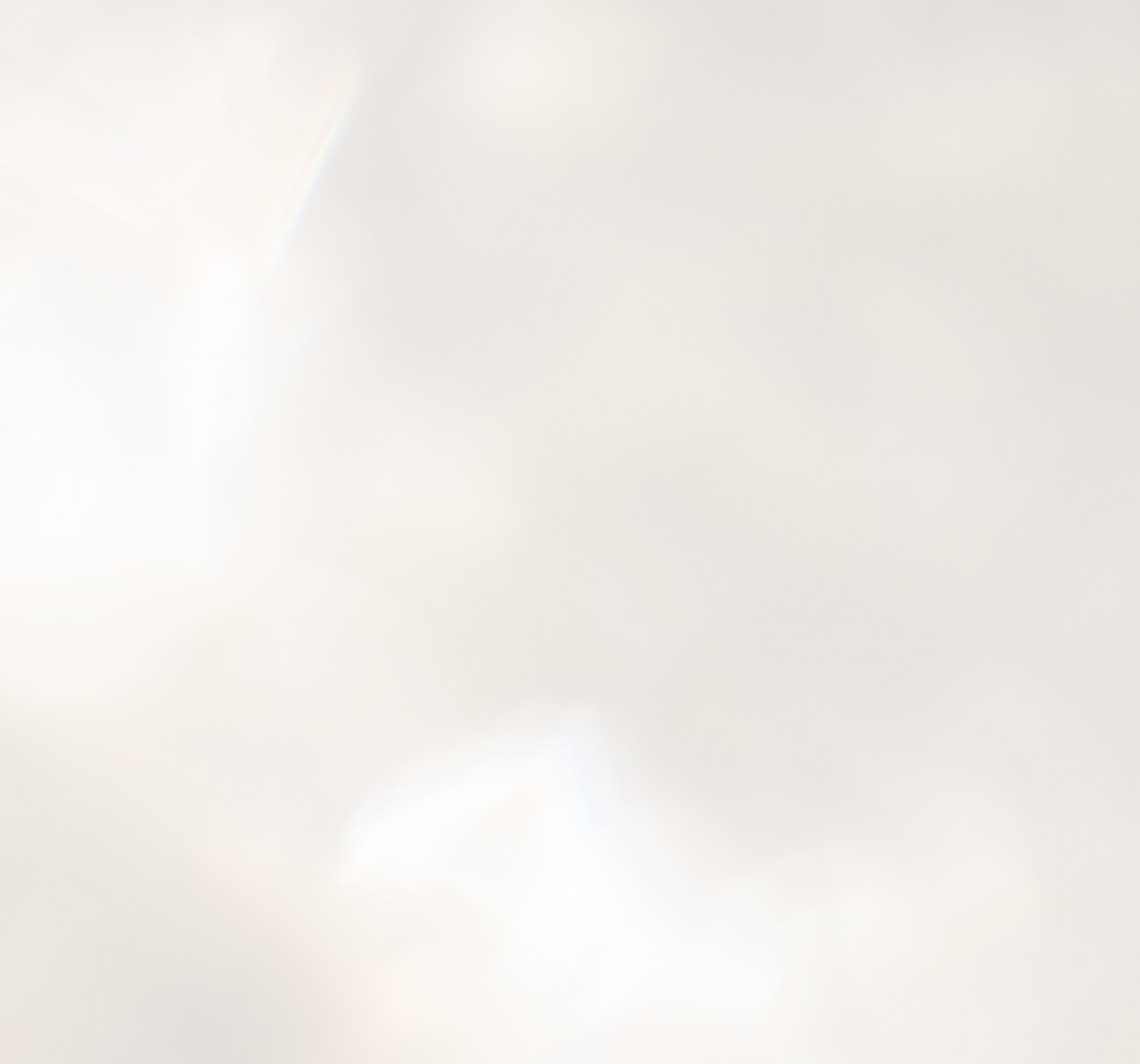 Soft, blurred white background with subtle light.