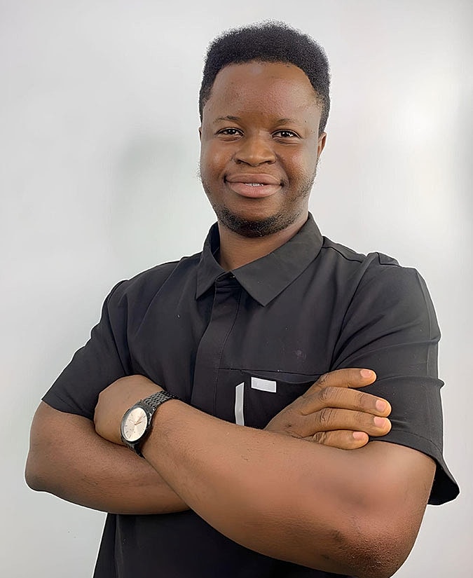 Smiling man posing with arms crossed.