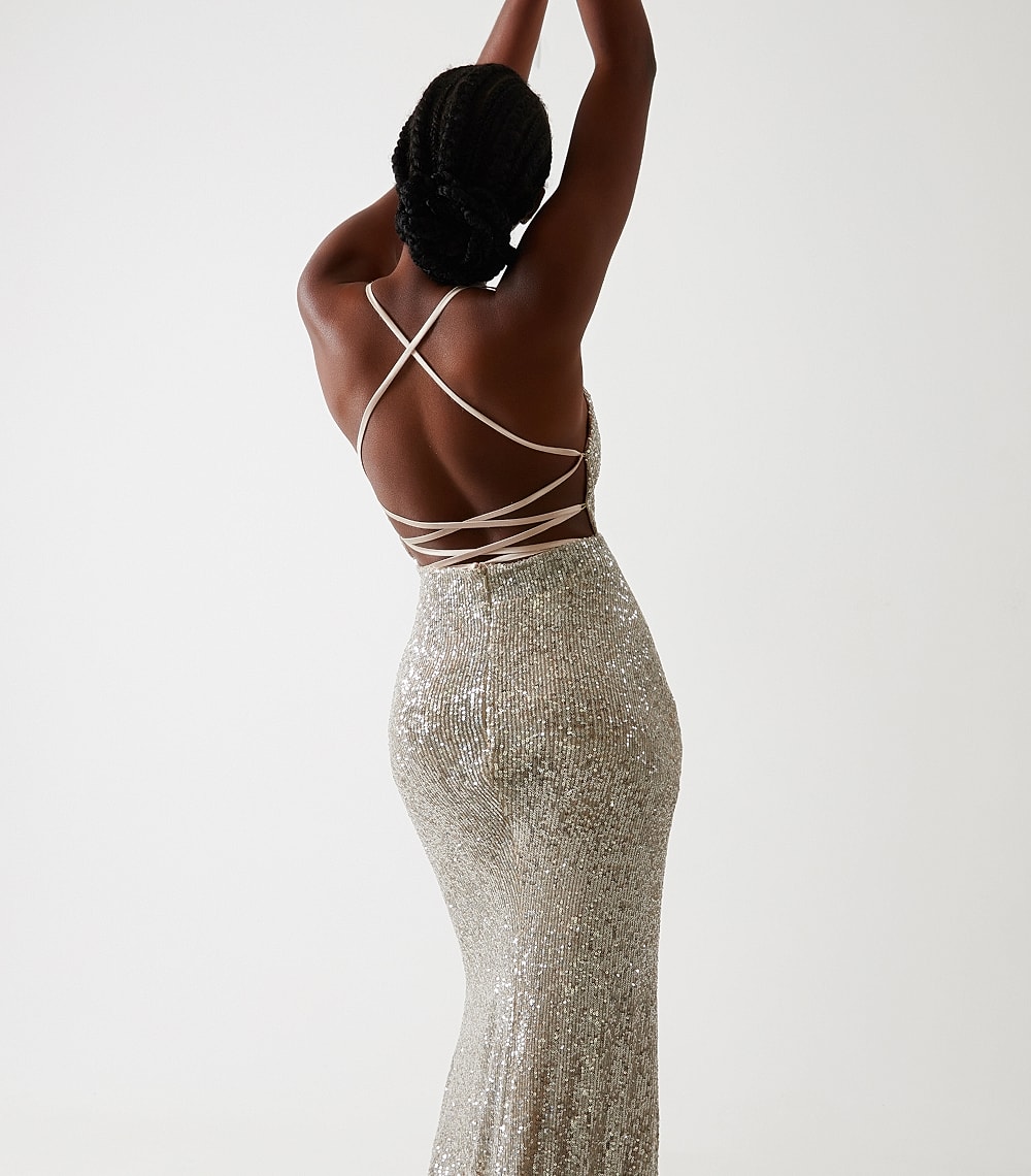 Elegant woman in sparkling silver dress from behind.