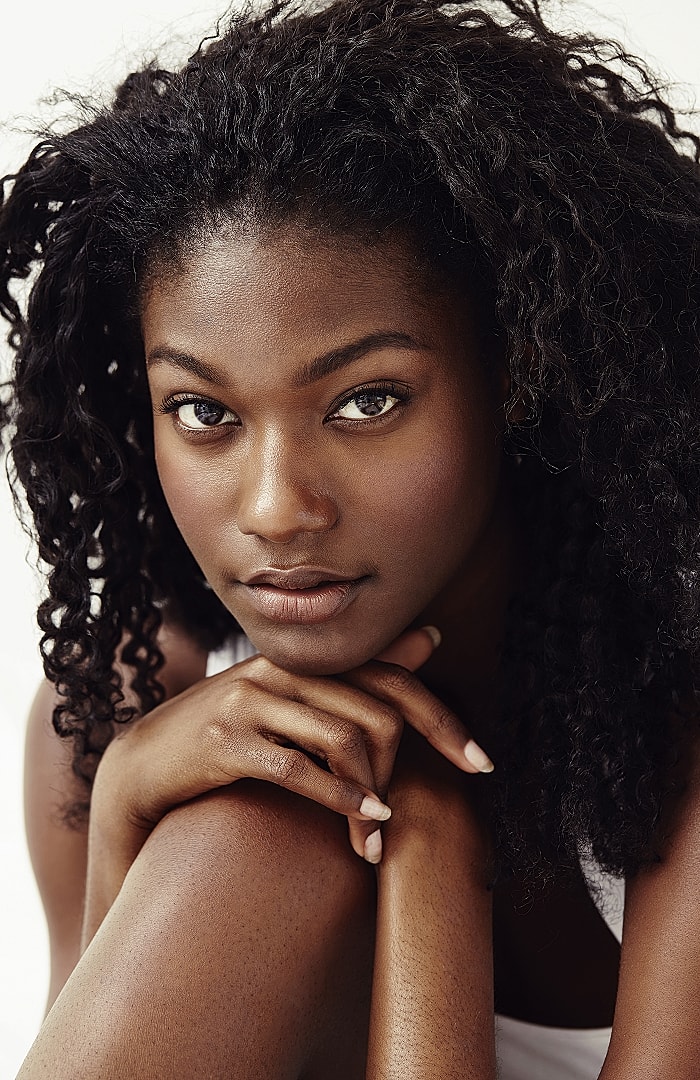 Close-up portrait of a woman with curly hair.
