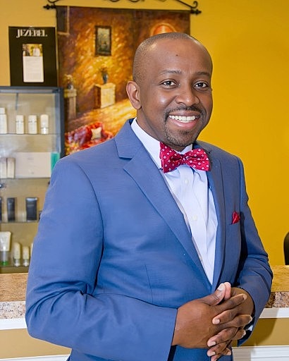 Smiling man in suit with bow tie.