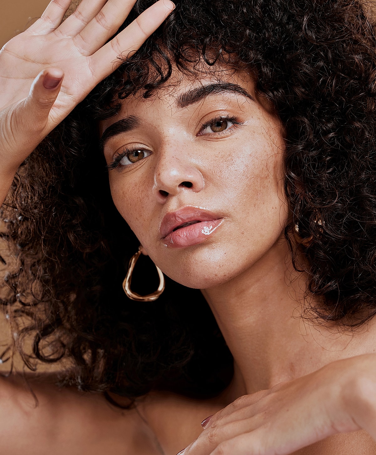 Abuja Brow Lift model with beautiful skin and red nail polish.