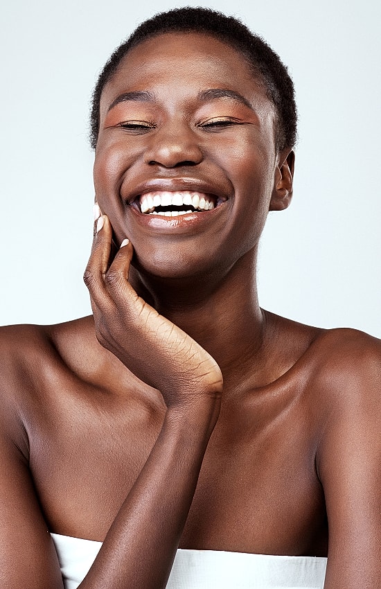 Smiling woman with short hair and glowing skin.