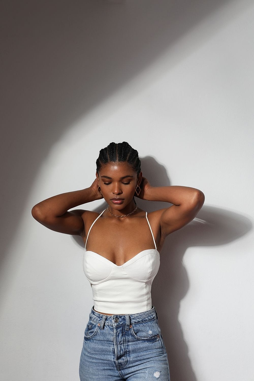 Model posing in light against a wall.