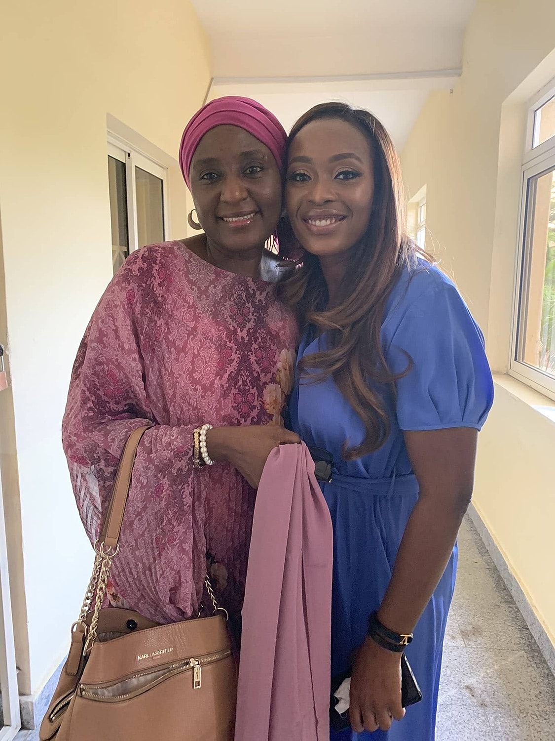 Two women smiling together indoors.