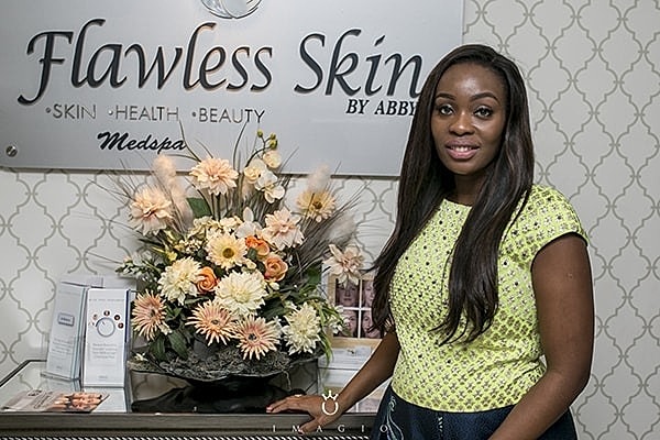 Woman posing at Flawless Skin Medspa reception.