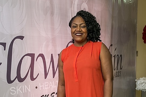 Smiling woman in bright outfit at event.