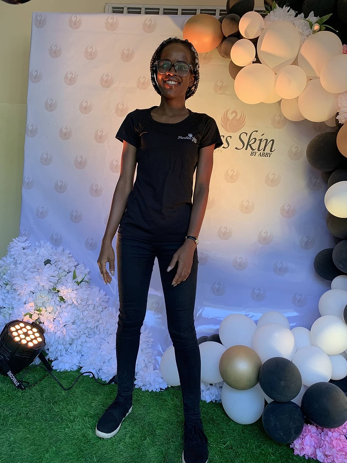 Person smiling in front of a decorative backdrop.