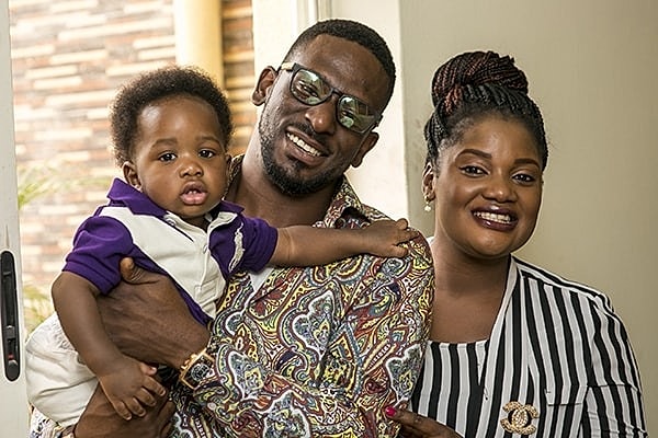 Family portrait with a smiling couple and child.