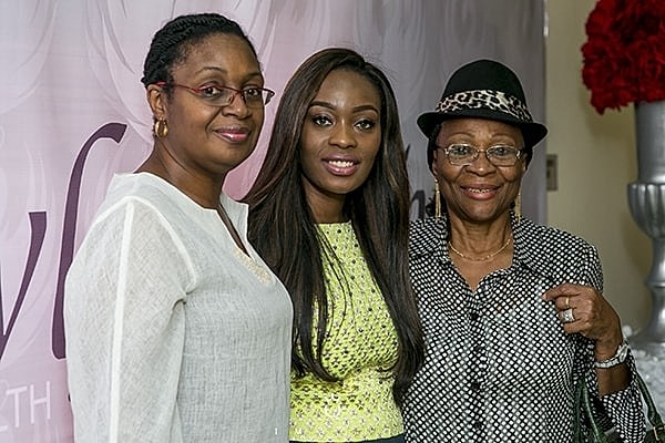 Three women posing together at an event.
