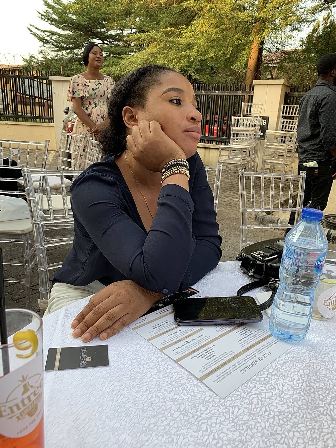 Woman resting chin on hand at a table.