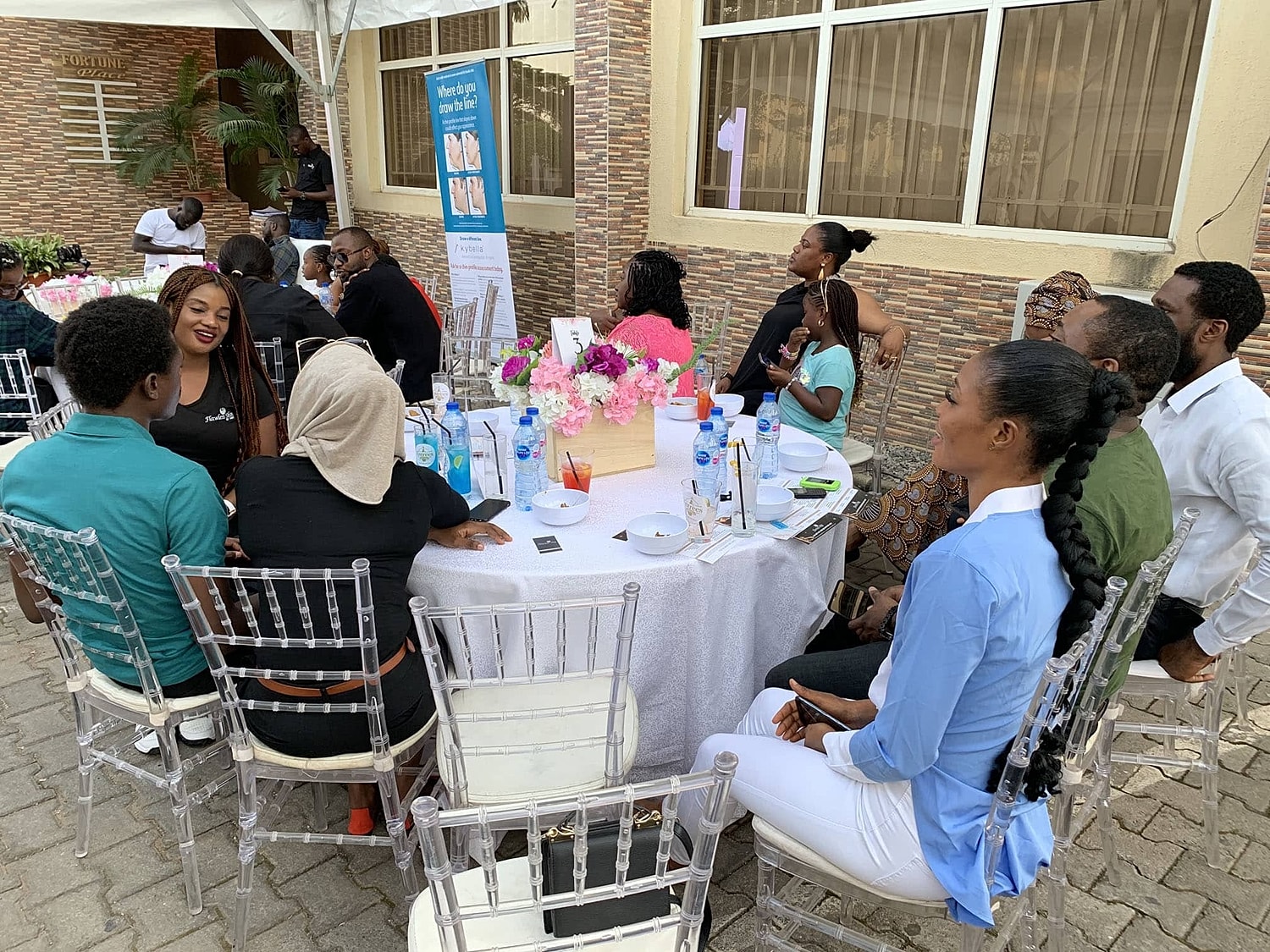 People chatting at a social gathering around tables.