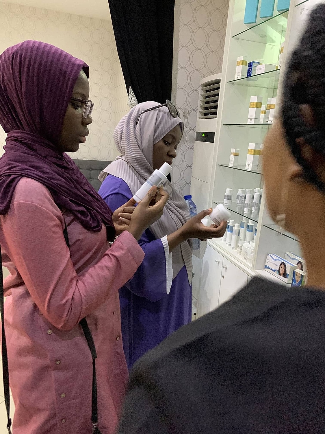 Women examining skincare products in a shop.
