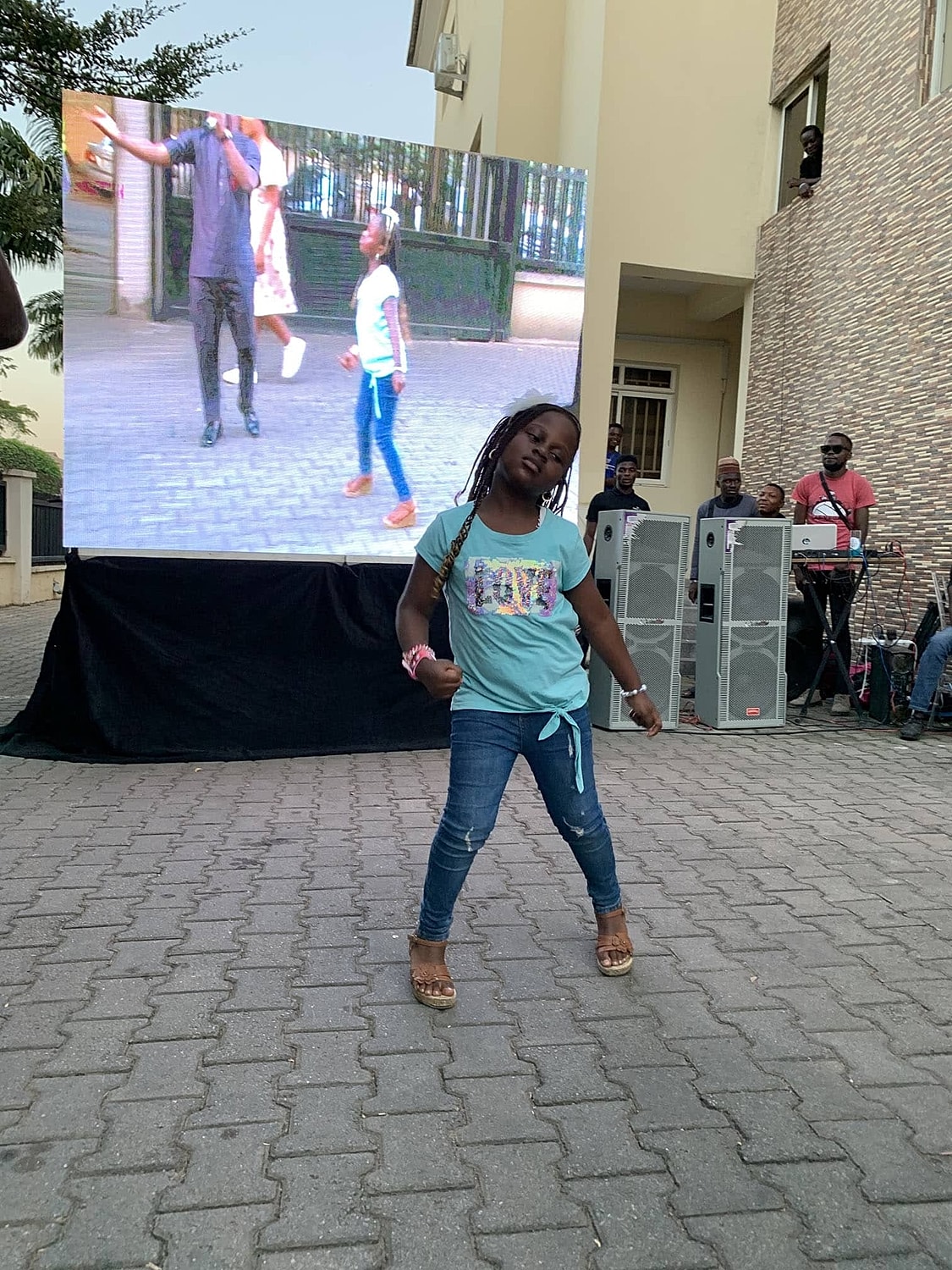 Girl posing confidently at outdoor event.