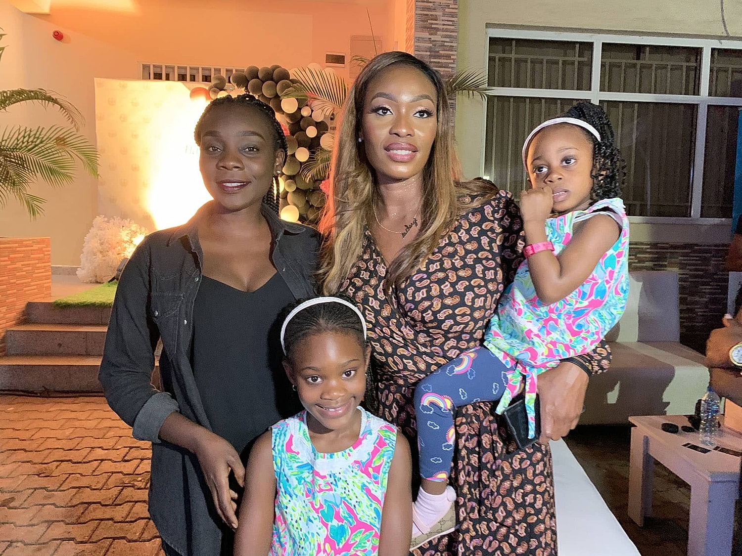 Women and children smiling at an event.