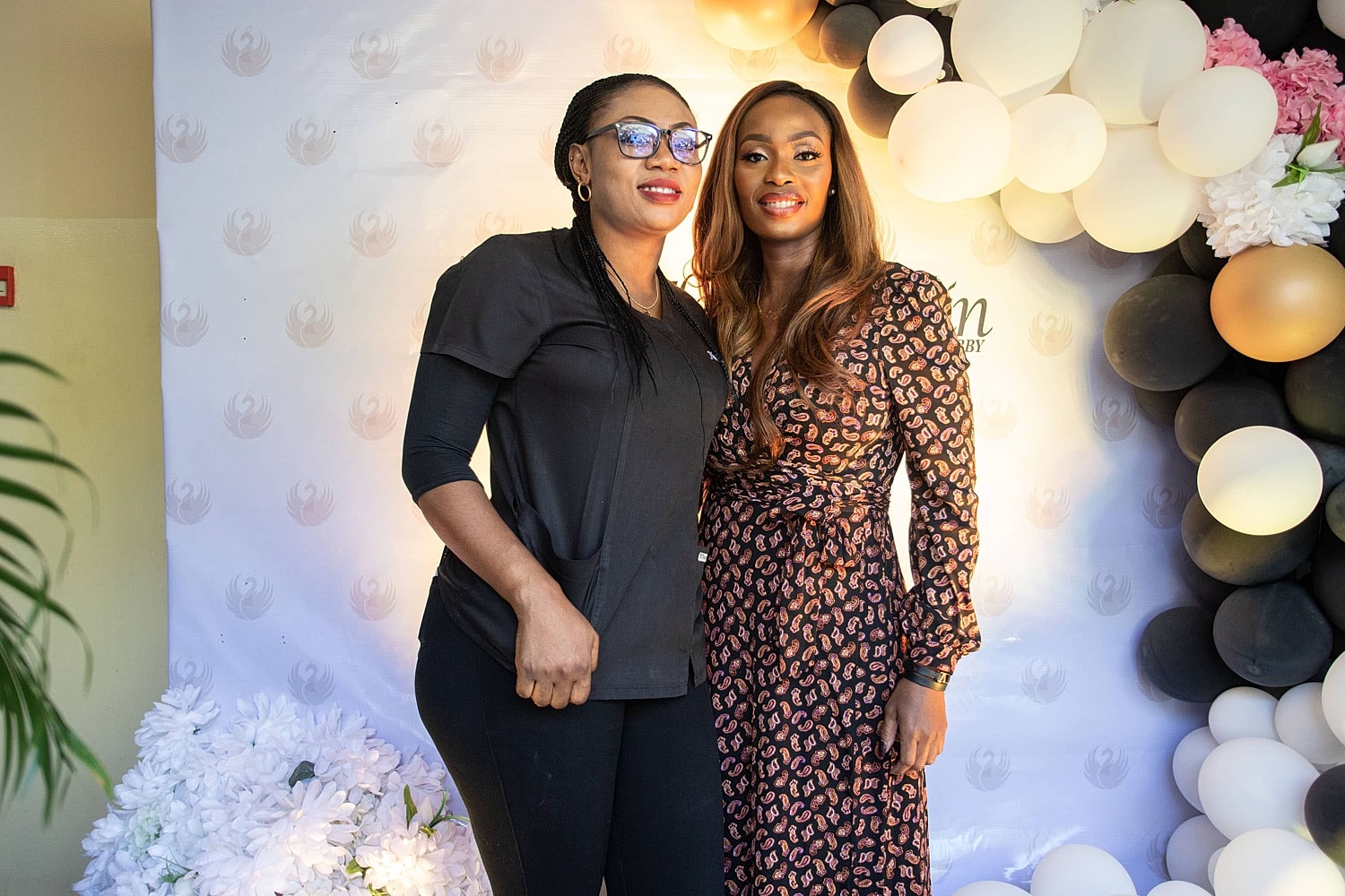 Two women posing at a celebratory event.