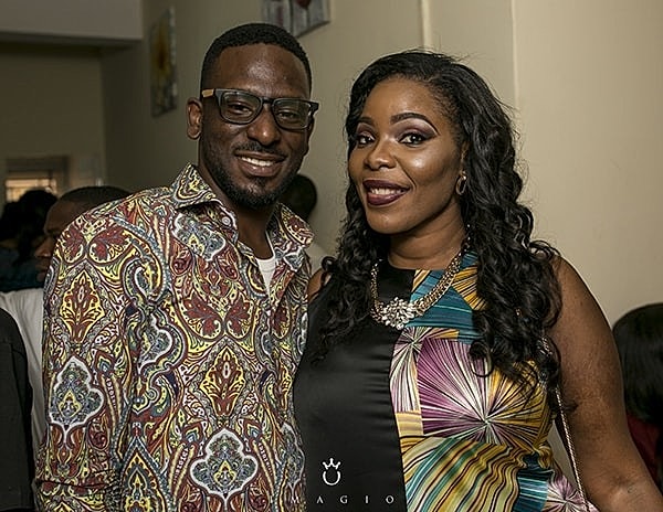 Smiling couple in colorful attire at event.