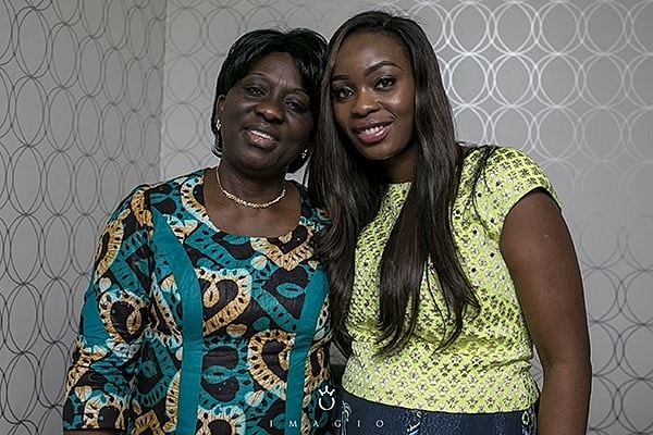 Smiling women posing together, wearing colorful outfits.