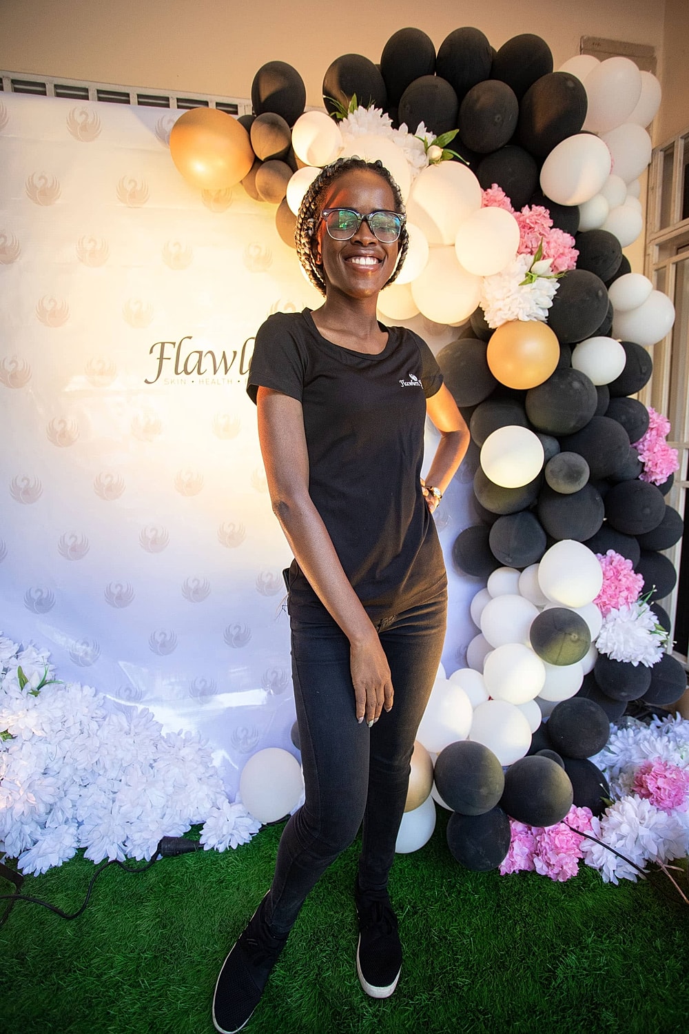 Woman smiling near a decorative balloon display.