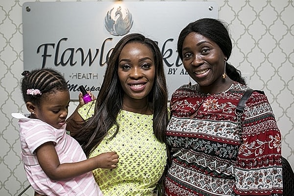 Women posing together with a child indoors.