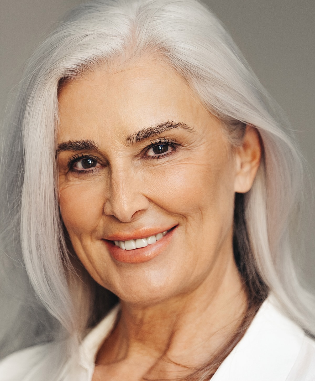 Abuja Blepharoplasty model with long silver hair.