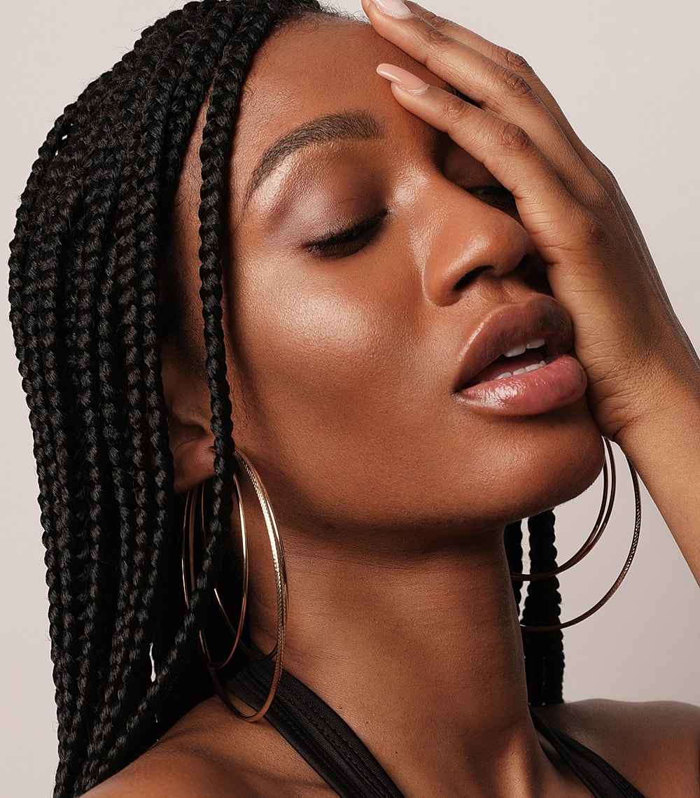 Woman with braided hair and hoop earrings.