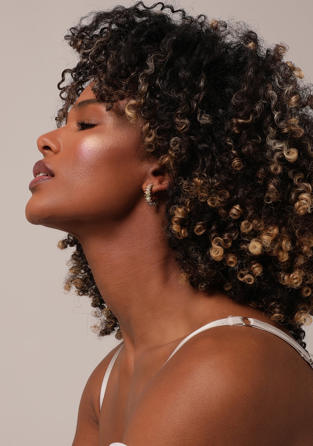 Woman with curly hair showing profile pose.
