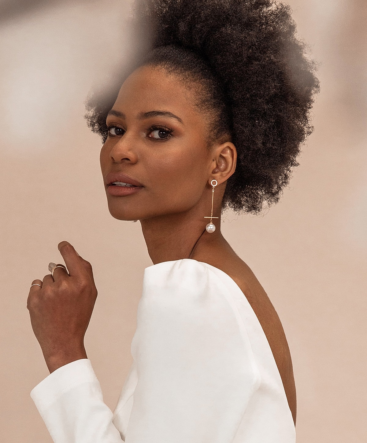 Abuja Laser Treatment model with curly hair and elegant jewelry.