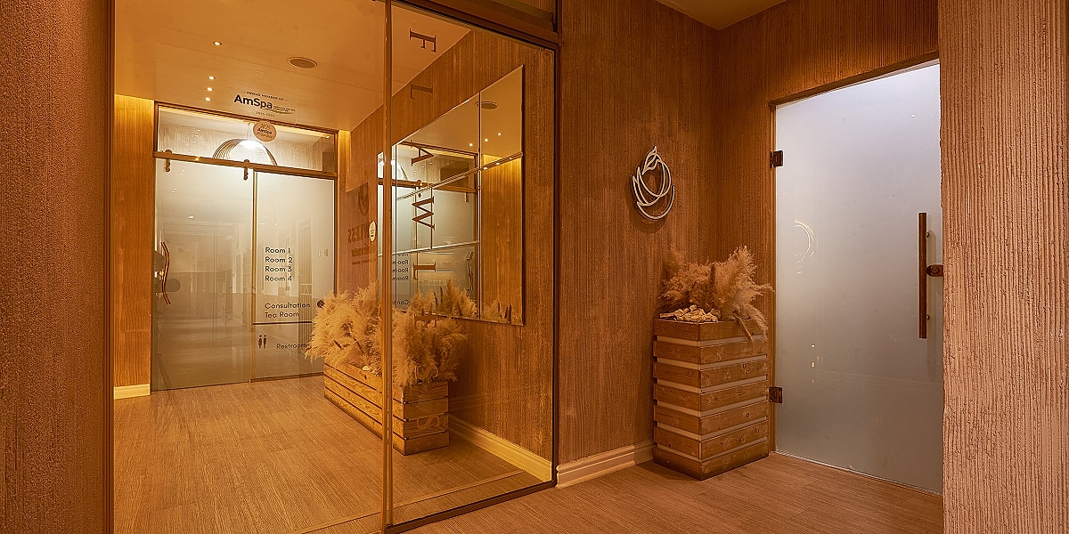 Elegant spa entrance with wooden decor and plants.