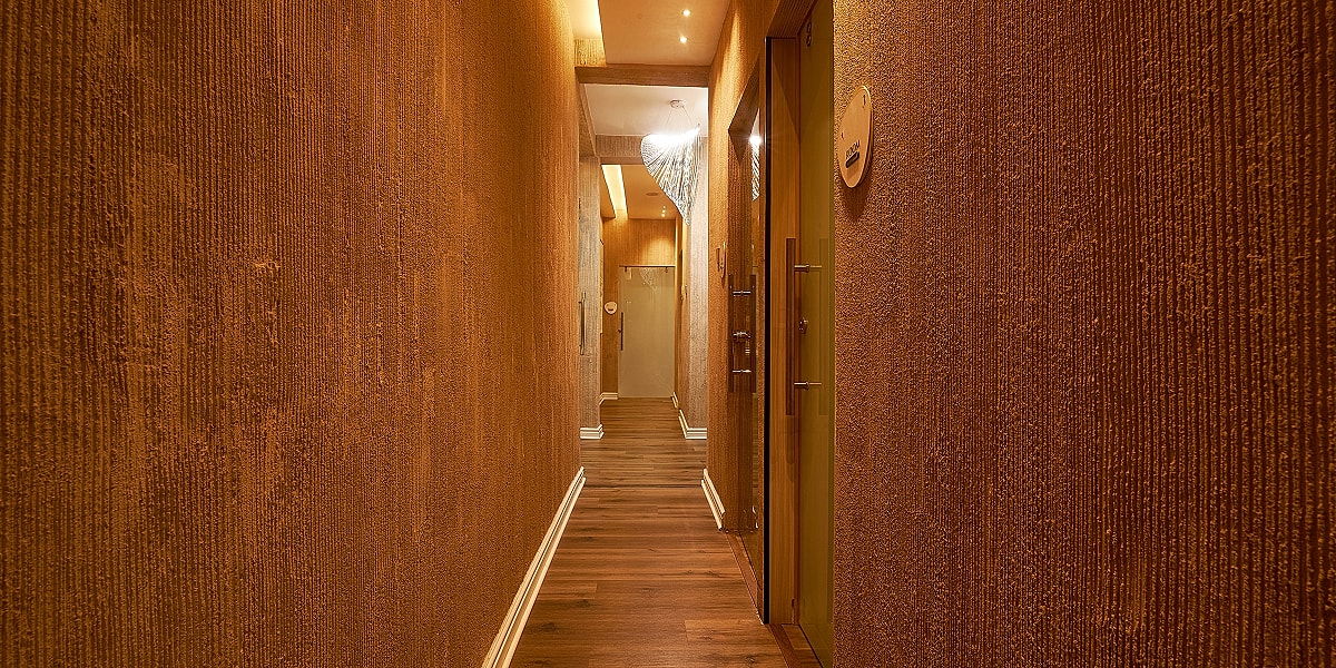 Modern hallway with textured walls and lighting.