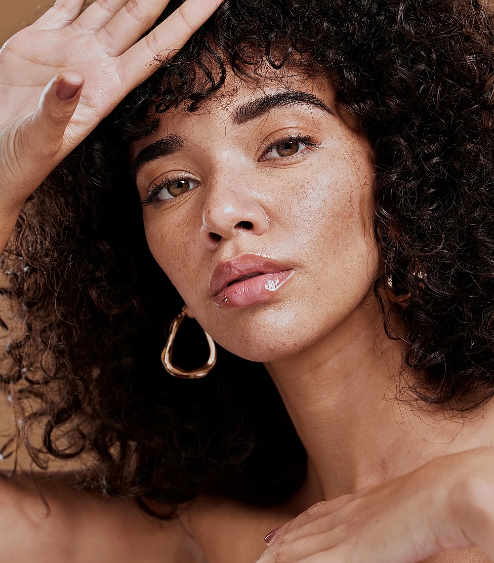 Woman with curly hair and natural makeup.