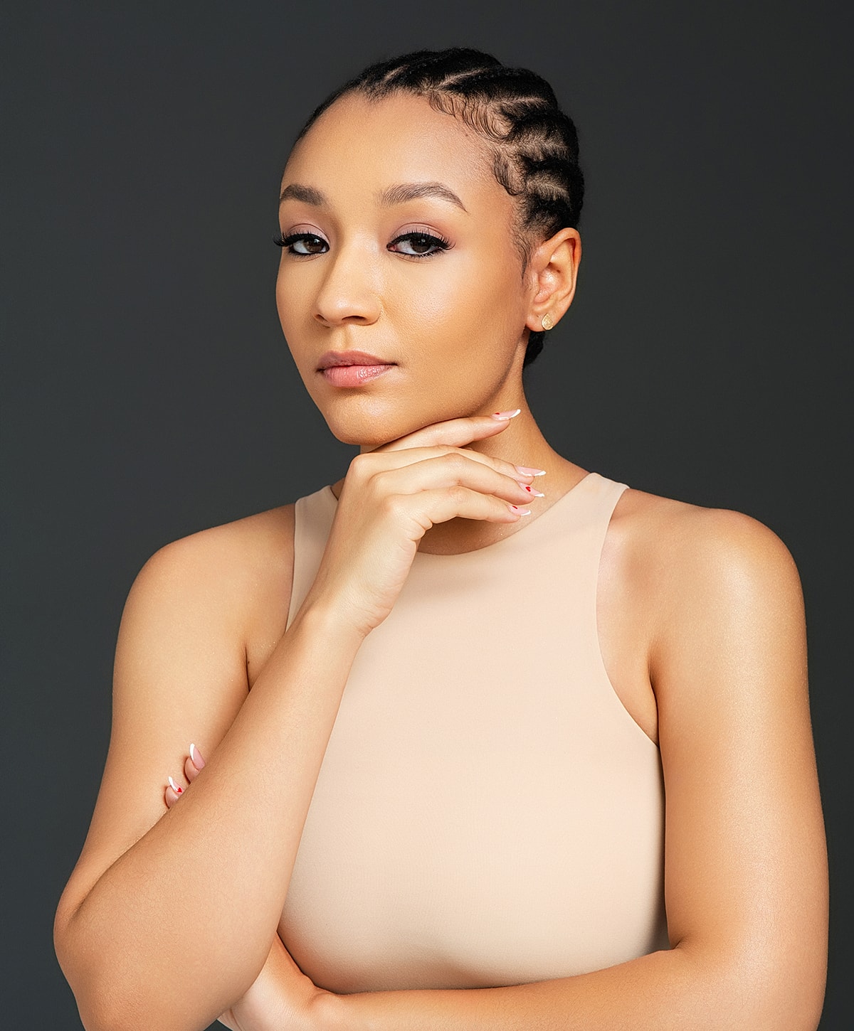 Woman posing thoughtfully with a neutral background.