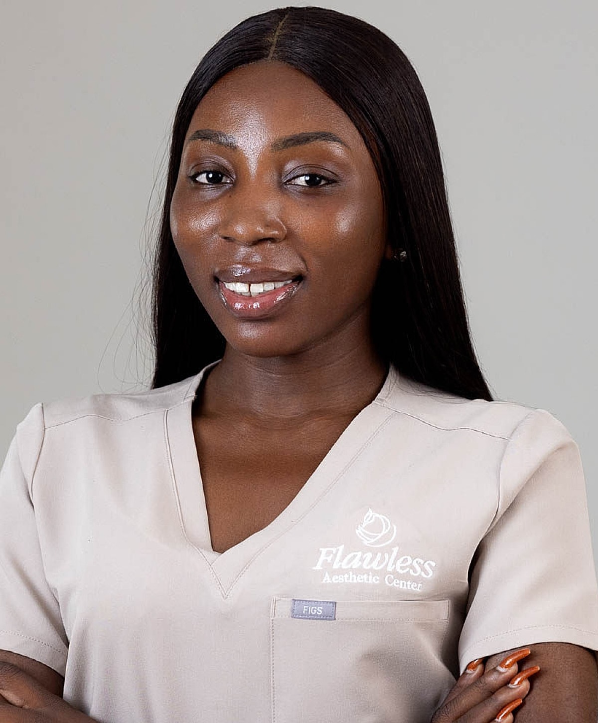 Woman in professional attire with skincare branding.