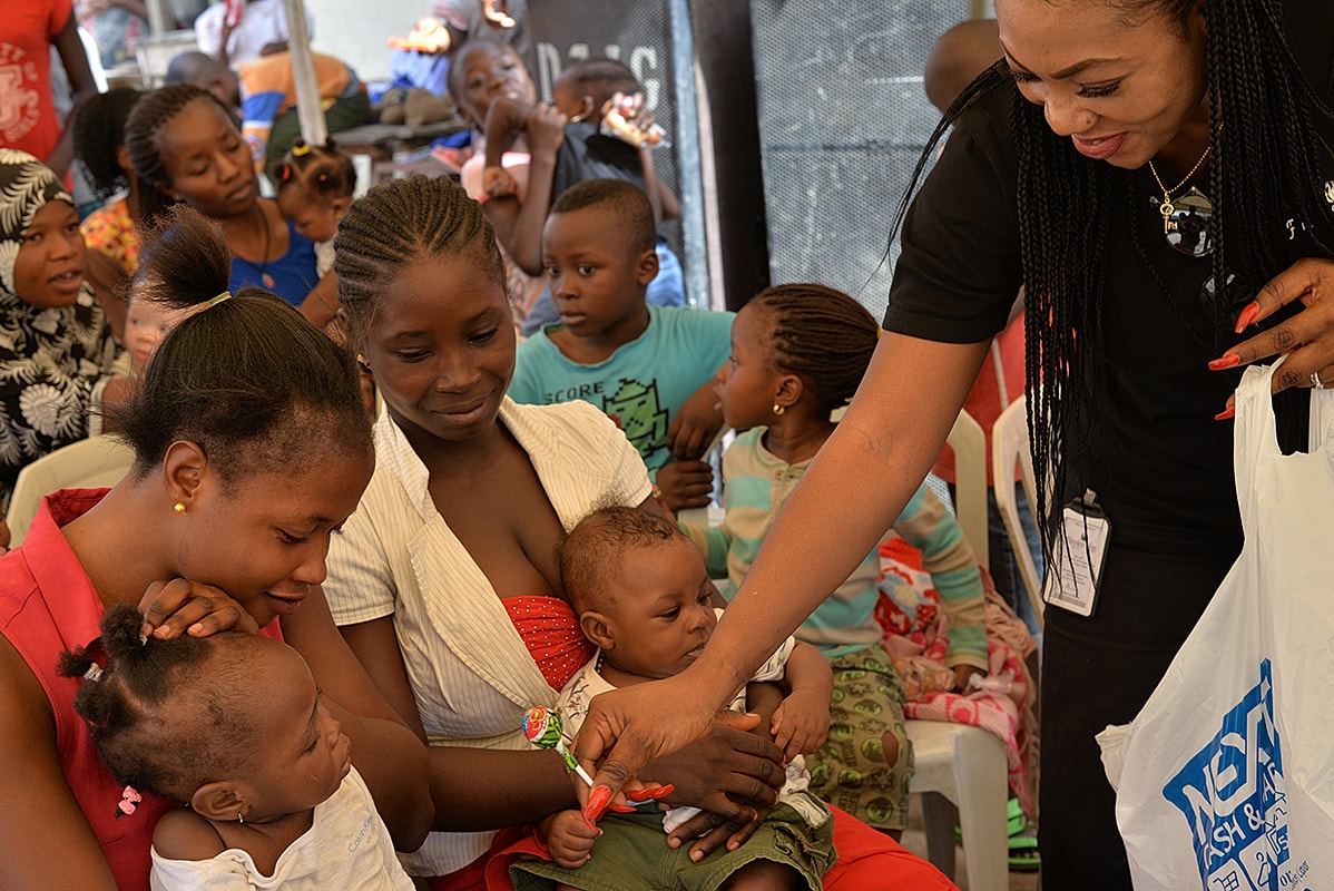 Women and children engaged in community gathering event.