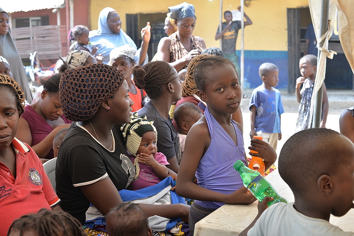 Group of women and children in community gathering.