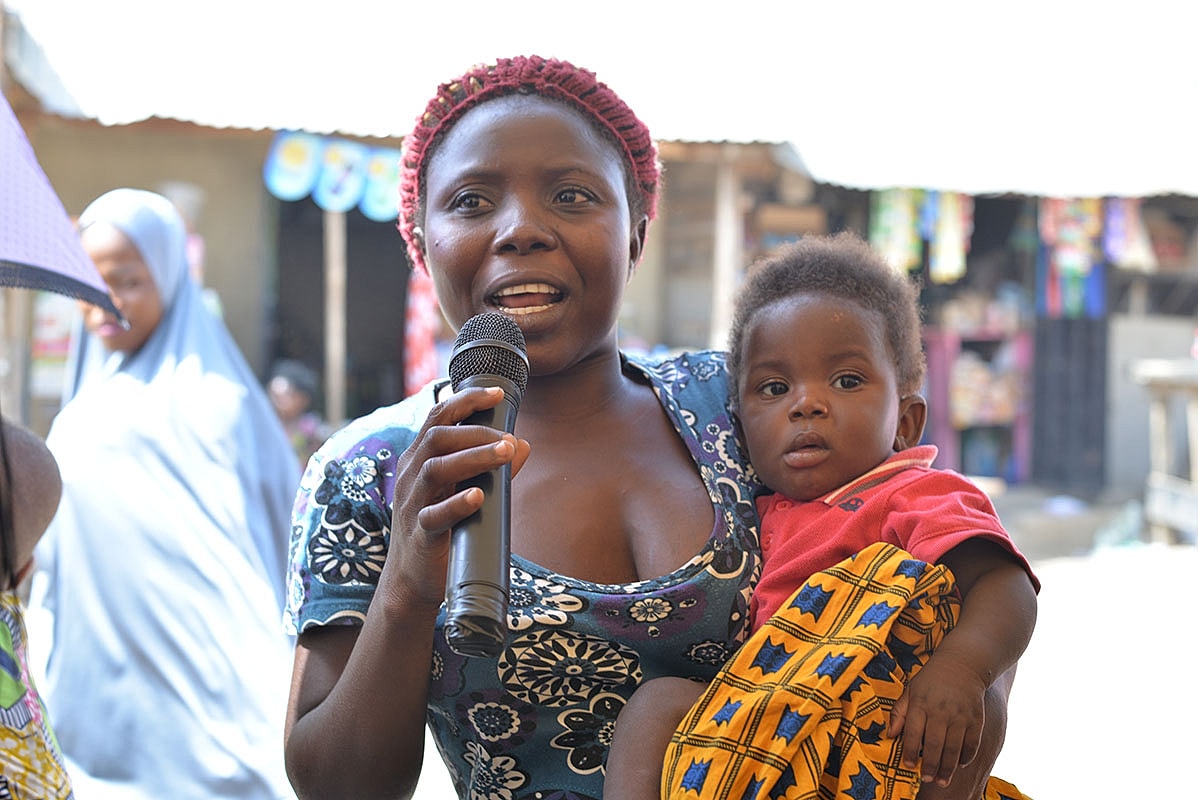 Woman smiling in a casual outdoor setting.