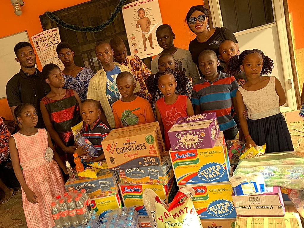 Group photo with children and food donations.