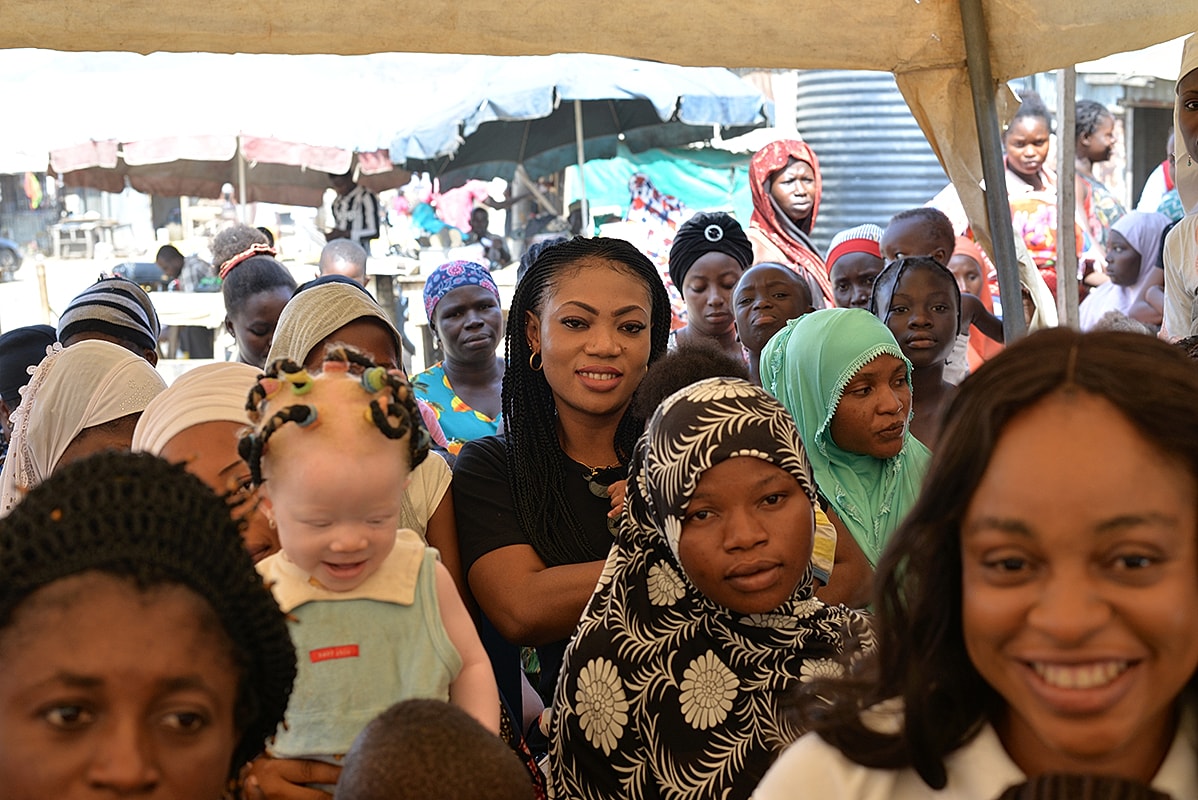 Diverse group of people smiling together outdoors.