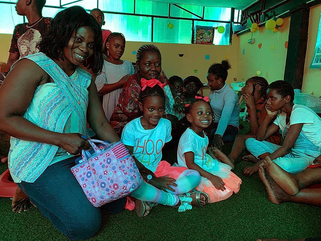 Group of smiling children and adults indoors.