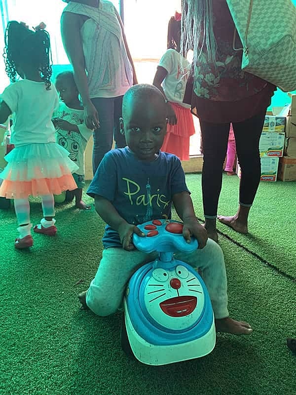Child playing with toy vehicle in colorful environment.