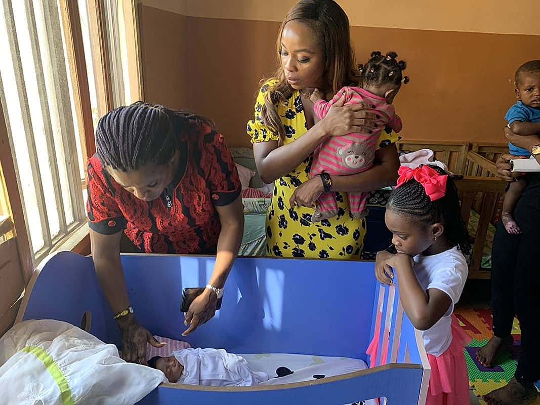 Women and children interacting in nursery setting.