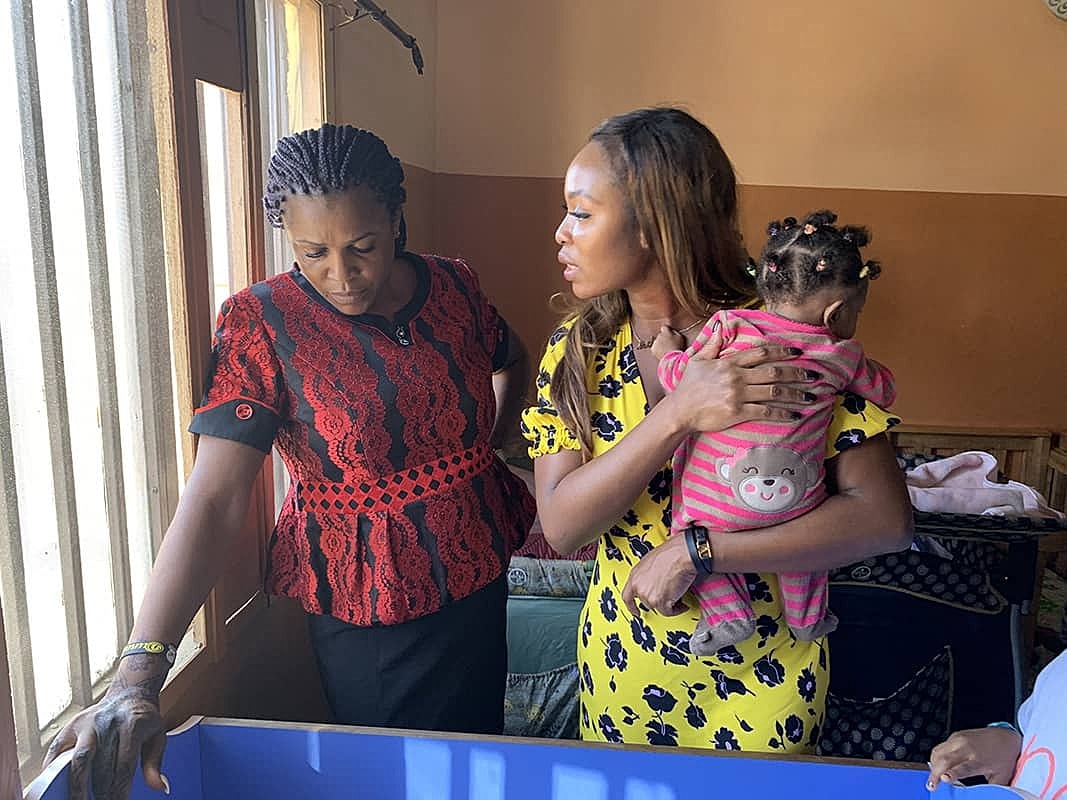 Two women interacting with a child indoors.