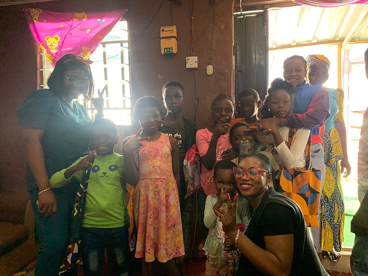 Group of children and adults smiling together indoors.