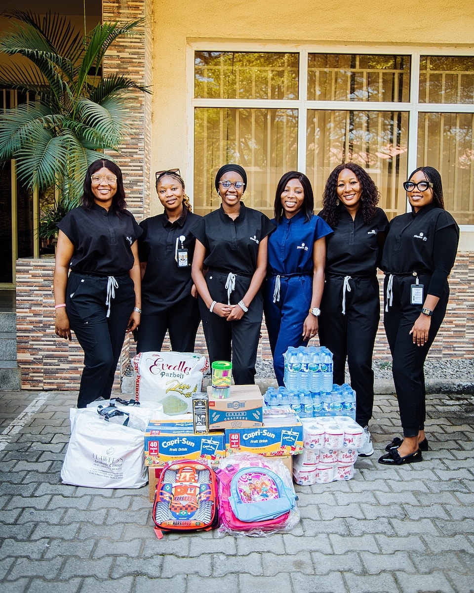 Women posing with donated supplies and backpacks.