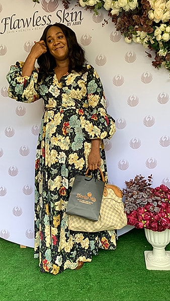Woman in floral dress at Flawless Skin event.