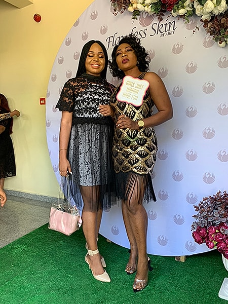 Two women posing at a celebration event.