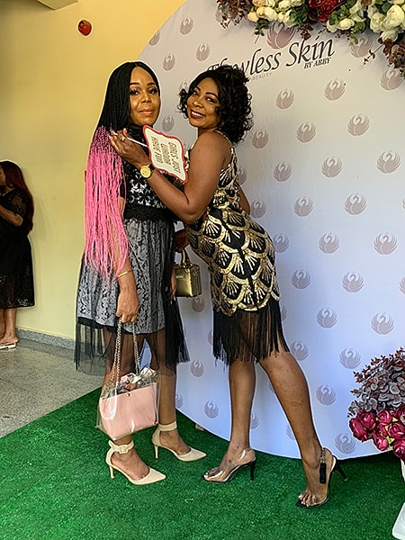 Two women posing at a stylish event.