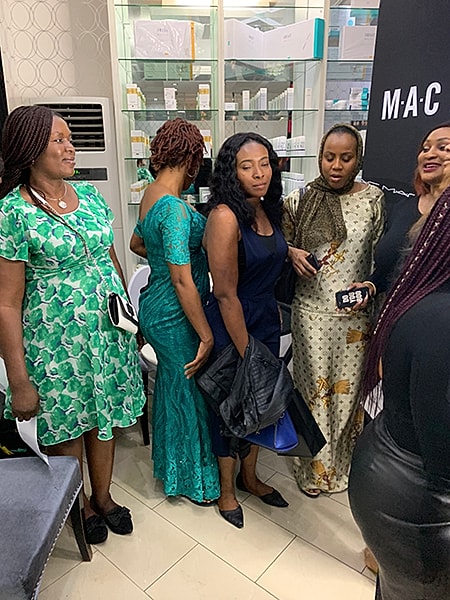 Women interacting at a beauty event.