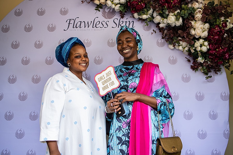 Two women posing with a fun sign.